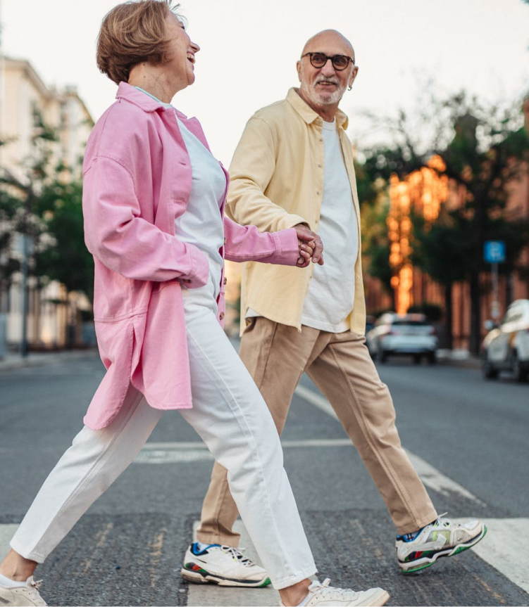 couple walking across road happily holding hands